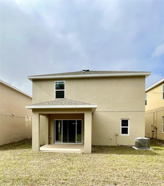 rear view of property featuring a yard, cooling unit, and a patio