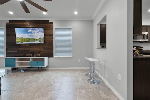 living room with ceiling fan, ornamental molding, and light tile patterned floors