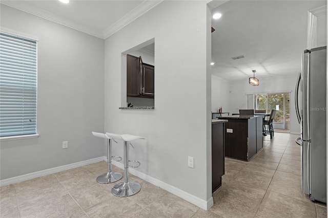 interior space with light tile patterned floors and ornamental molding