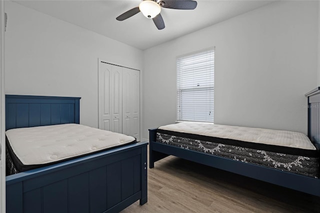 bedroom with ceiling fan, light wood-type flooring, and a closet