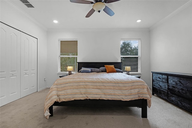 carpeted bedroom featuring ceiling fan, a closet, and ornamental molding