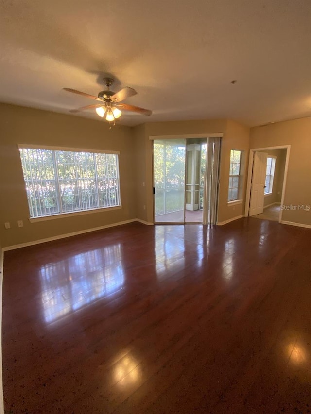 unfurnished room with ceiling fan and dark wood-type flooring