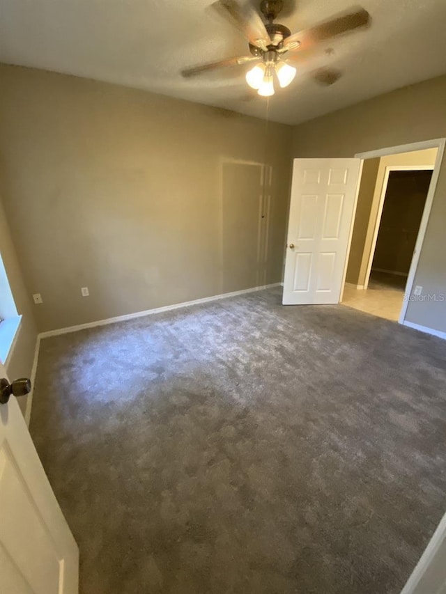 unfurnished bedroom featuring dark colored carpet and ceiling fan