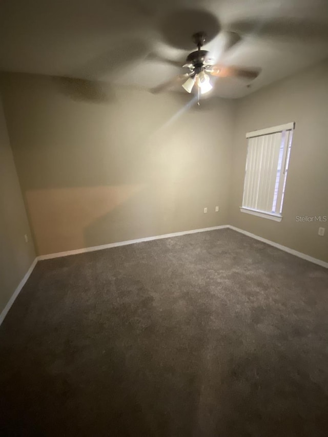 carpeted spare room featuring ceiling fan