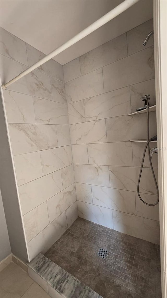 bathroom featuring tile patterned flooring and a tile shower