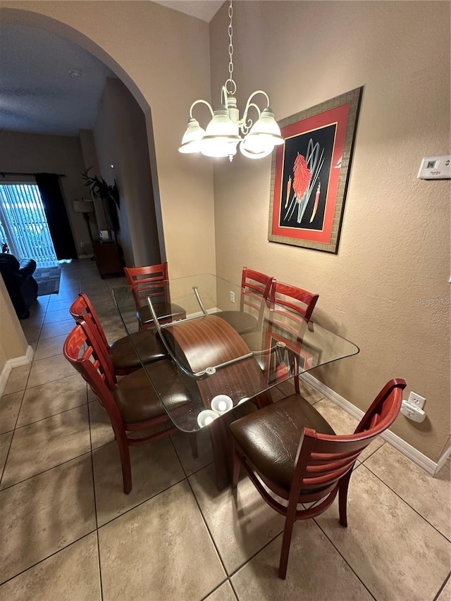 tiled dining area with a chandelier