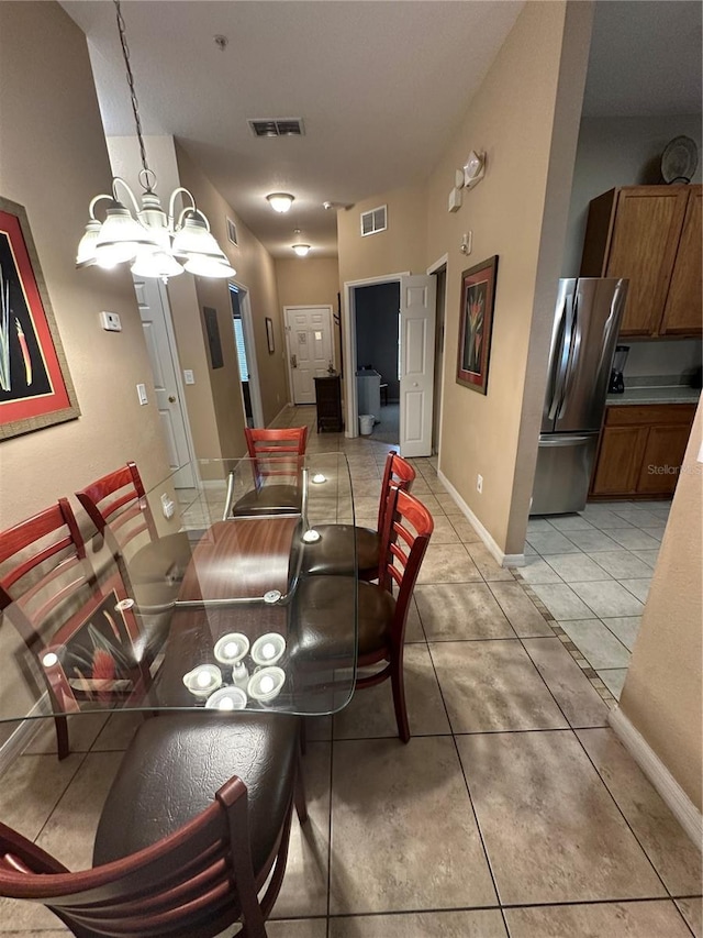 dining space with a chandelier and light tile patterned floors