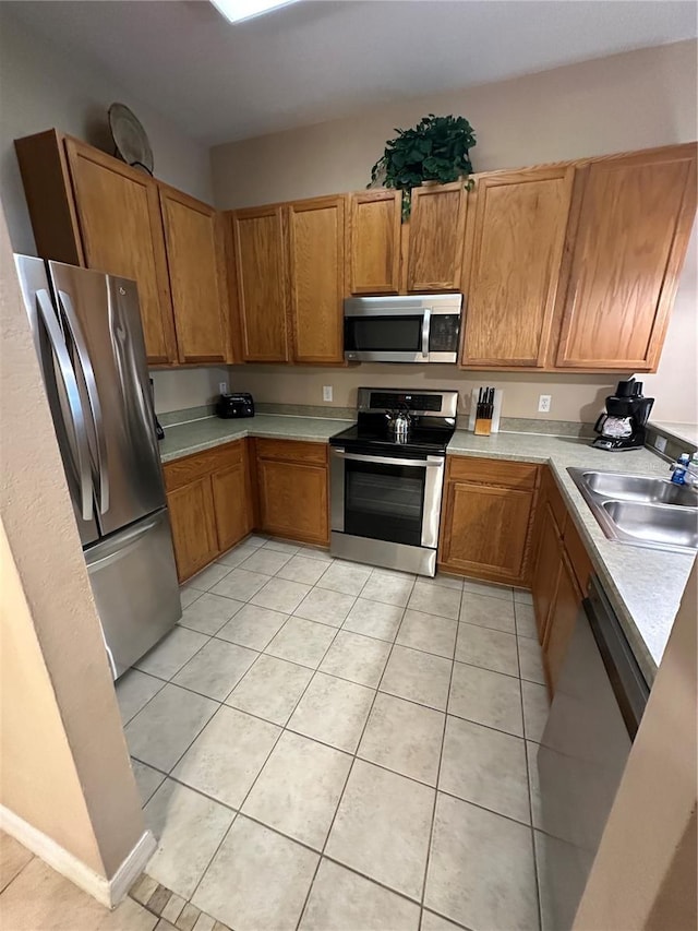 kitchen with light tile patterned flooring, appliances with stainless steel finishes, and sink