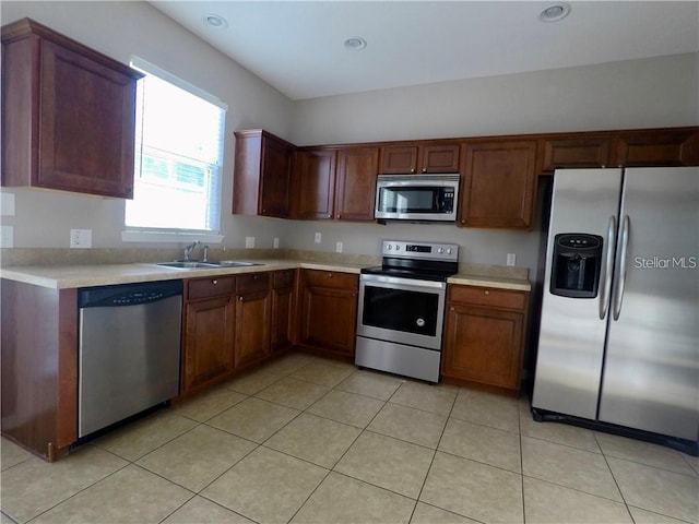 kitchen with sink, light tile patterned floors, and appliances with stainless steel finishes