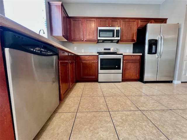 kitchen with light tile patterned floors, appliances with stainless steel finishes, and light countertops