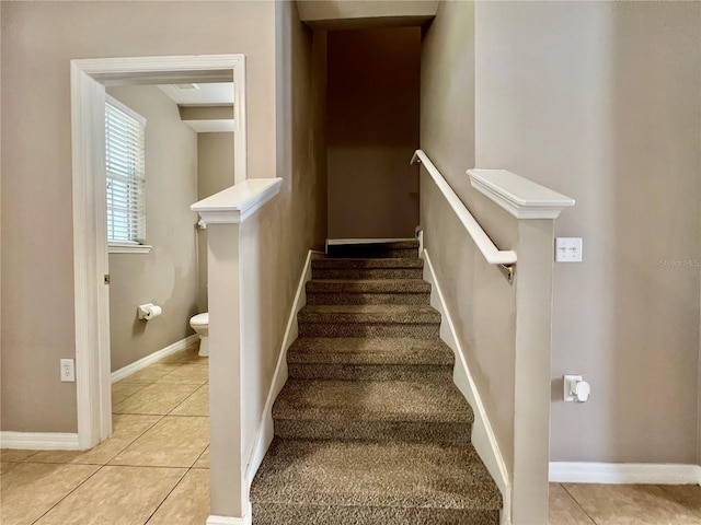 stairway featuring baseboards and tile patterned flooring