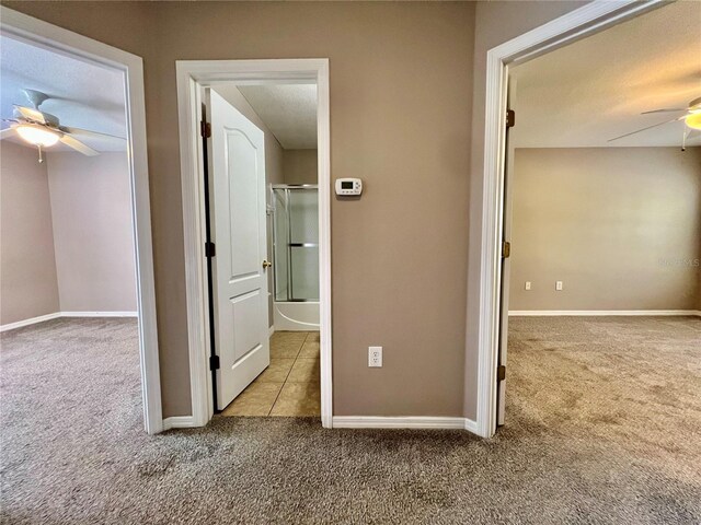 hall with baseboards and carpet floors