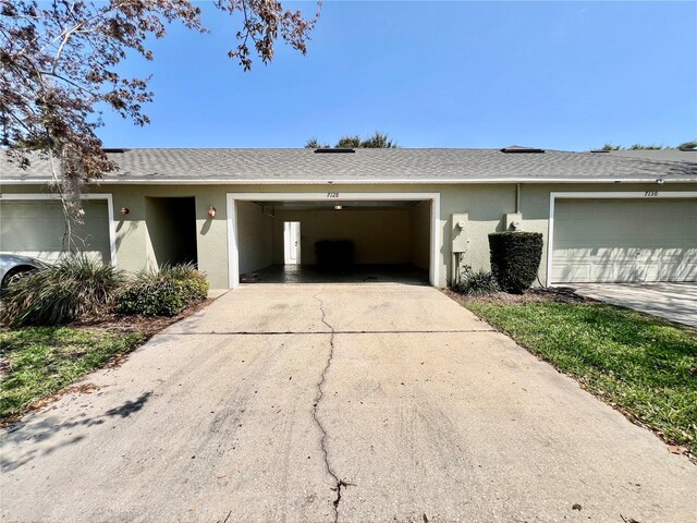 exterior space featuring stucco siding, driveway, a garage, and roof with shingles