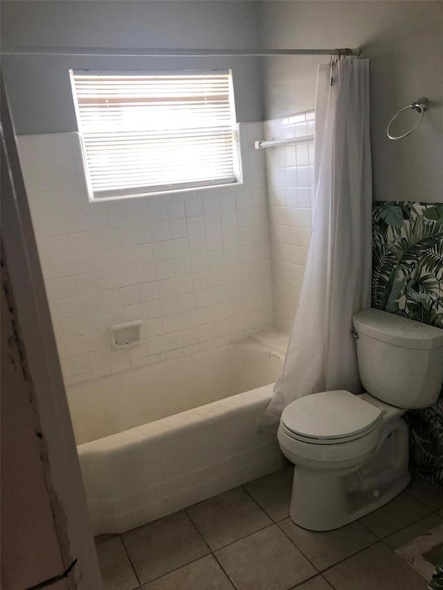 bathroom featuring tile patterned flooring, toilet, and shower / tub combo