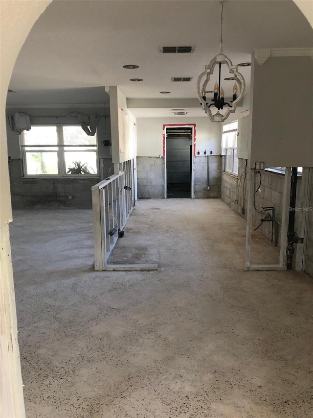 interior space with elevator, plenty of natural light, and a chandelier