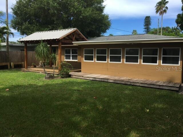 rear view of property featuring a yard