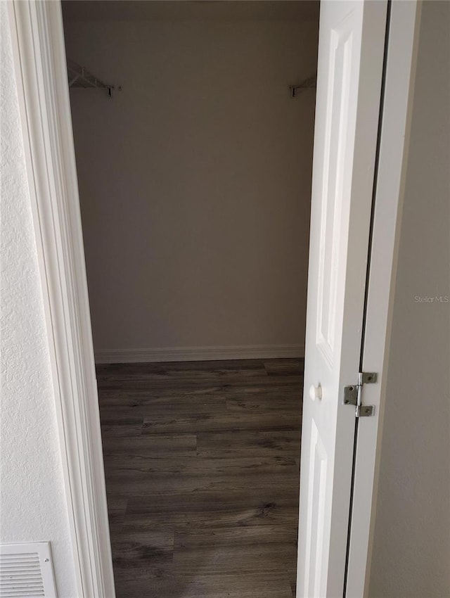 spacious closet featuring dark hardwood / wood-style flooring