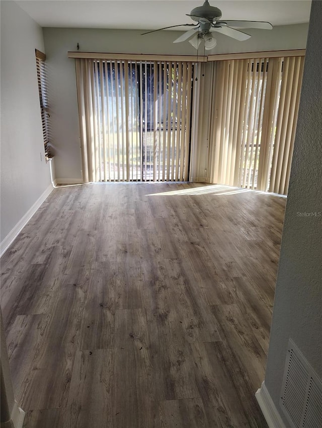 empty room with hardwood / wood-style floors and ceiling fan