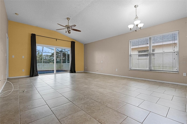 spare room with ceiling fan with notable chandelier, light tile patterned flooring, lofted ceiling, and a textured ceiling