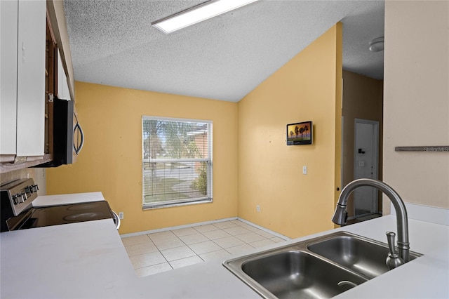 kitchen with electric range oven, a textured ceiling, vaulted ceiling, sink, and white cabinets