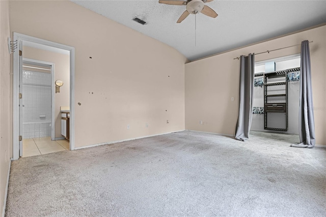 unfurnished room with ceiling fan, light colored carpet, a textured ceiling, and vaulted ceiling