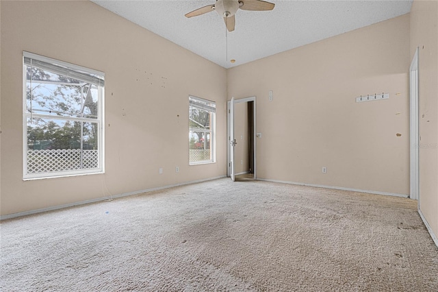 carpeted empty room with ceiling fan, a textured ceiling, and vaulted ceiling