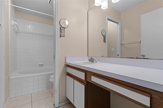 full bathroom featuring tile patterned floors, vanity, toilet, and tiled shower / bath combo