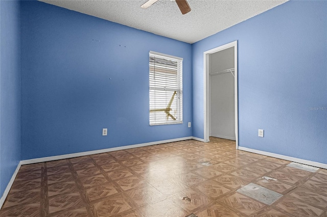 empty room featuring ceiling fan and a textured ceiling