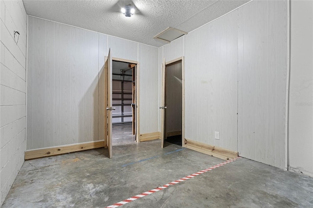 spare room featuring concrete flooring and a textured ceiling