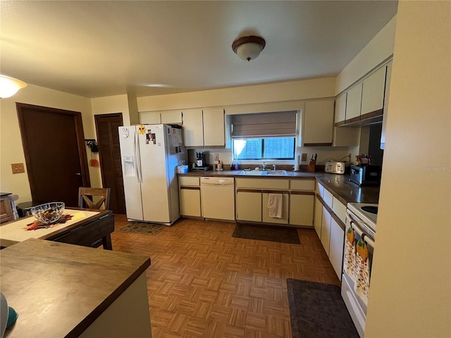 kitchen featuring white appliances, sink, and light parquet floors