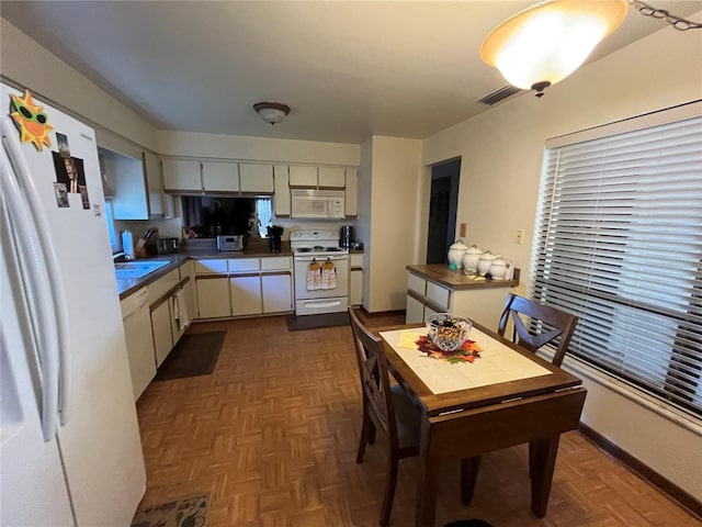 kitchen featuring white cabinetry, dark parquet floors, white appliances, and sink