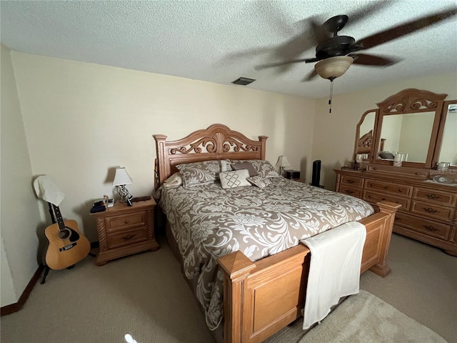 carpeted bedroom with ceiling fan and a textured ceiling