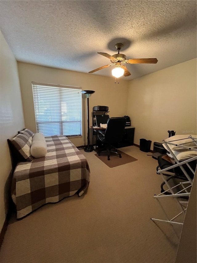 bedroom featuring ceiling fan, carpet floors, and a textured ceiling