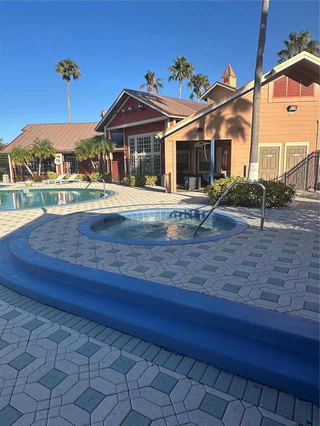 view of swimming pool featuring a patio and a hot tub