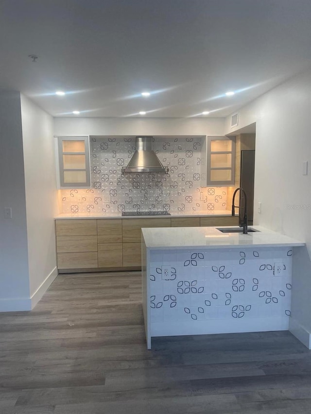 kitchen featuring backsplash, sink, wall chimney exhaust hood, dark hardwood / wood-style flooring, and kitchen peninsula