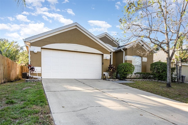 ranch-style house with cooling unit, a garage, and a front yard