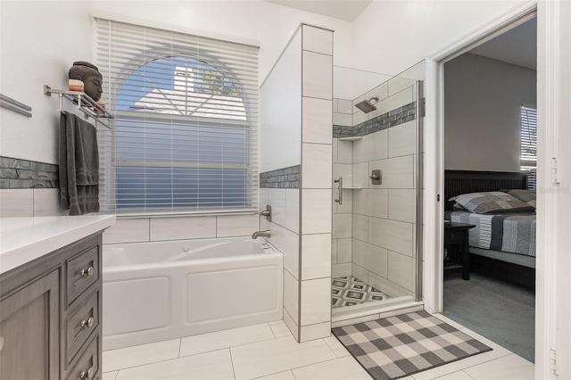 bathroom with tile patterned flooring, vanity, and shower with separate bathtub