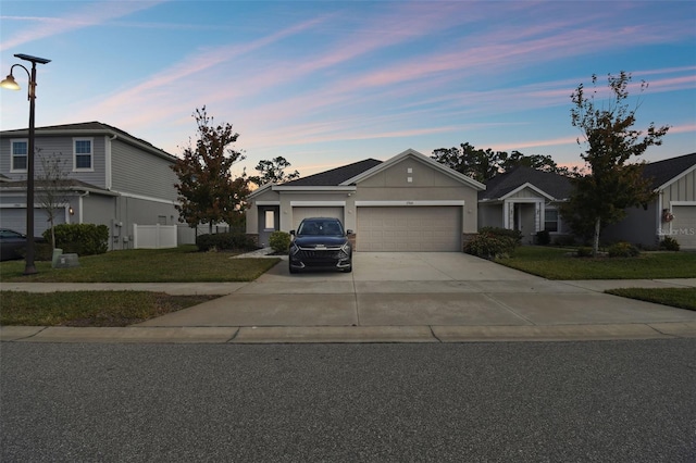 view of front facade featuring an attached garage, fence, driveway, stucco siding, and a front yard