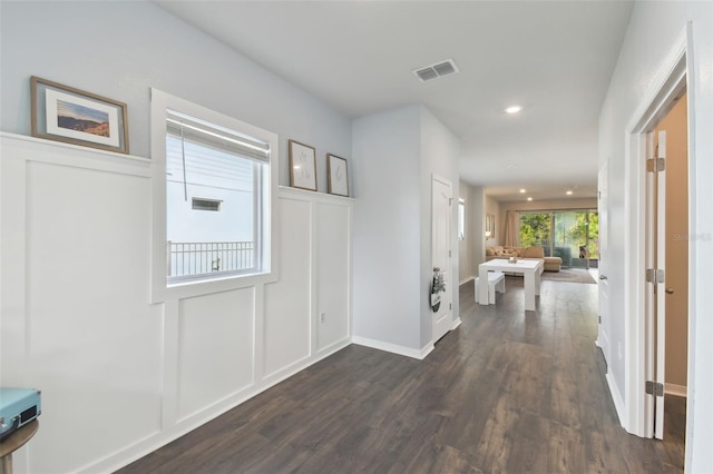 entrance foyer with recessed lighting, a decorative wall, dark wood-style flooring, visible vents, and baseboards