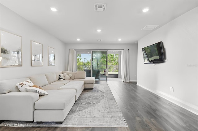 living room with recessed lighting, visible vents, and wood finished floors