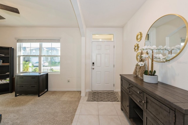 tiled entryway featuring beam ceiling