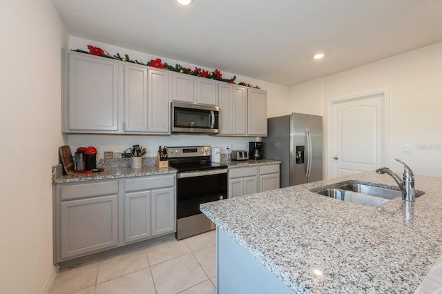 kitchen with gray cabinets, light stone countertops, sink, and appliances with stainless steel finishes