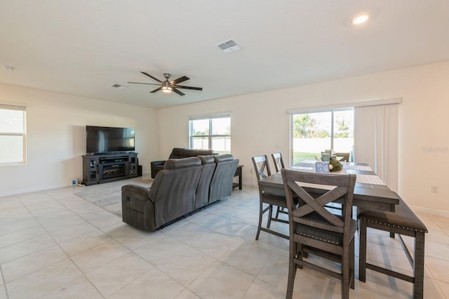 tiled dining room with a wealth of natural light and ceiling fan