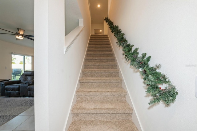 stairway featuring tile patterned floors and ceiling fan