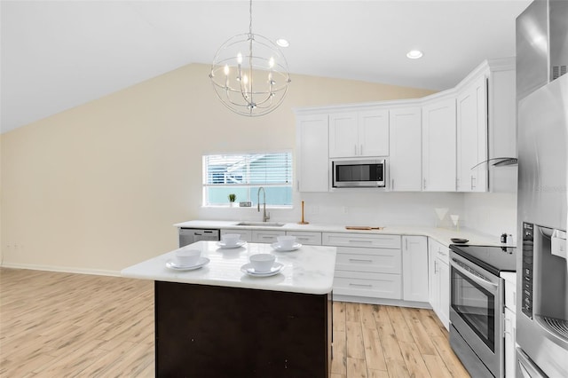 kitchen featuring sink, a kitchen island, white cabinets, and appliances with stainless steel finishes