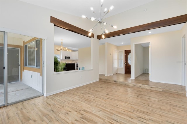 unfurnished living room featuring a chandelier, beam ceiling, and light hardwood / wood-style floors