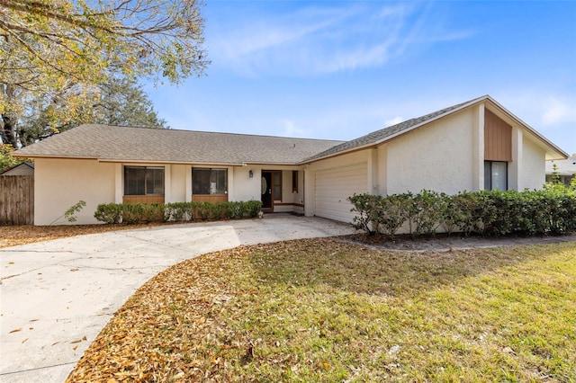 ranch-style home with a garage and a front lawn