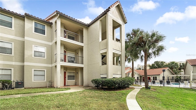 view of property featuring central AC unit and a pool