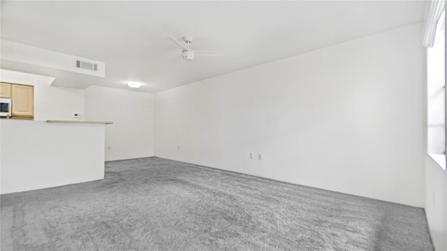 unfurnished living room with ceiling fan and carpet floors