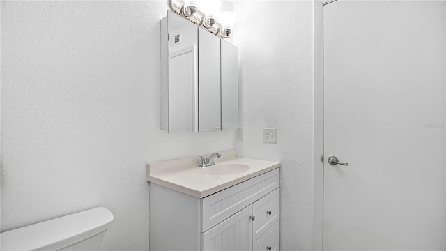 bathroom featuring vanity and toilet